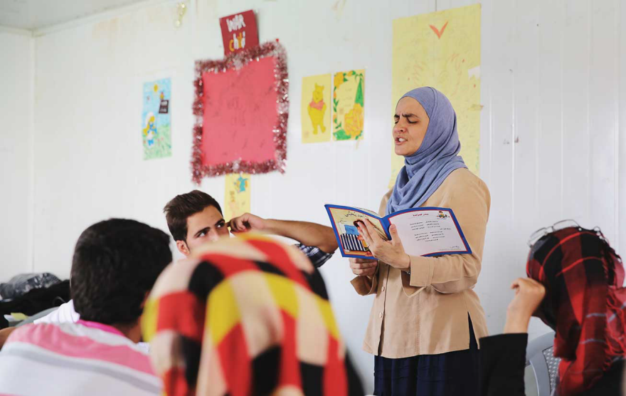 Ashoka Fellow Rana Dajani reading in front of a group of people. 