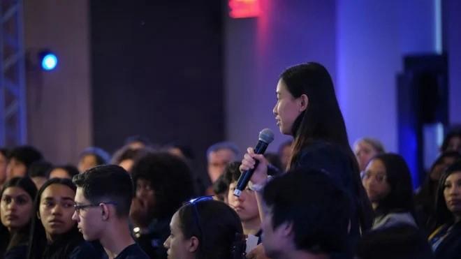 Girl in the public holding a microphone during a conference