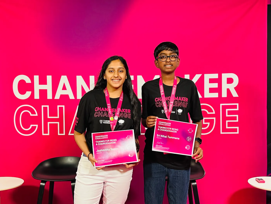 The Recycle My Battery team at the 2022 T-Mobile Changemaker Lab standing in front of a Changemaker Challenge sign and holding awards.