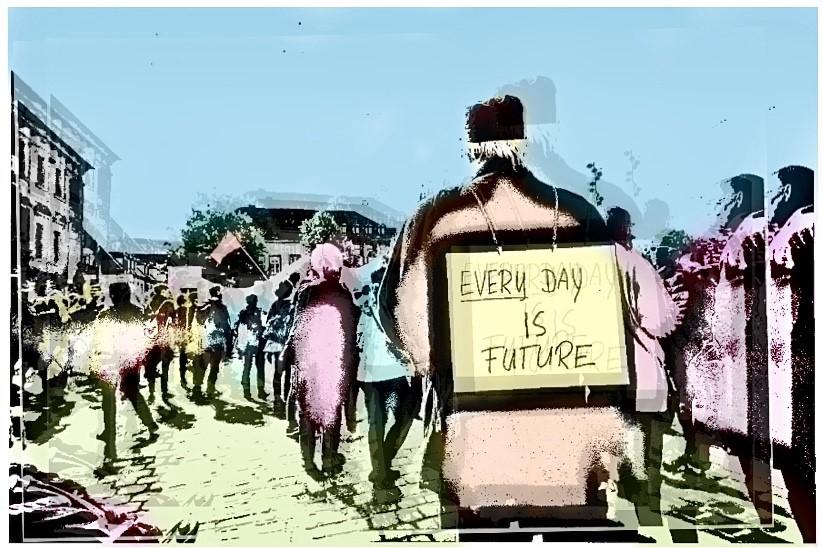 A person is carrying a sign in their back that says 'Every day is future'